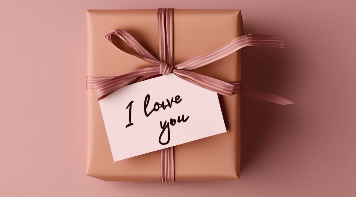 Caja de regalo envuelta con un lazo y una nota que dice I love you.